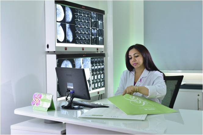Dr. Norran Hussein reviewing mammogram and breast MRI images in Dubai clinic, expert in breast imaging and cancer detection.